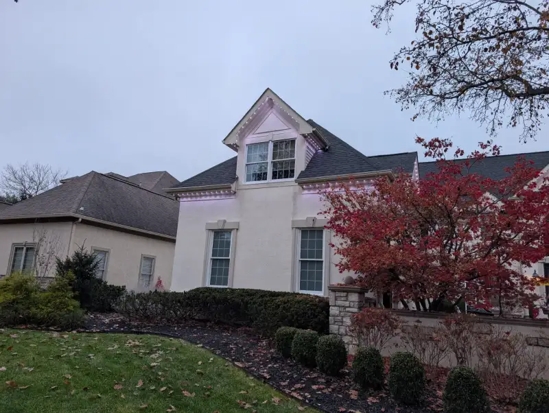 Permanent LED lights installed on stucco home during daytime
